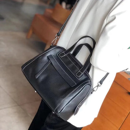 Genuine leather horizontal messenger bag in wine red with shoulder strap and internal zippered compartments.