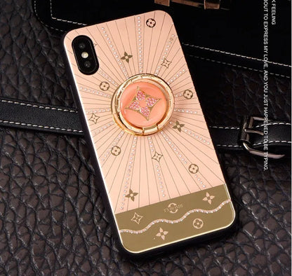 Luxury diamond and gold ring stand attached to the back of an iPhone in rose gold colour.