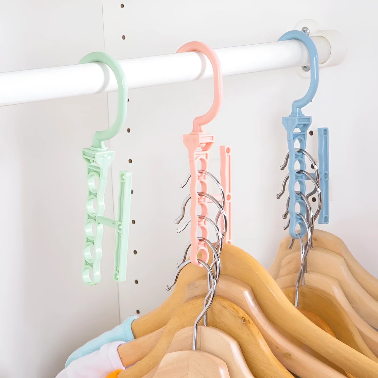 Blue revolving wardrobe hanger with five branches and a handle for multiple garment organisation.