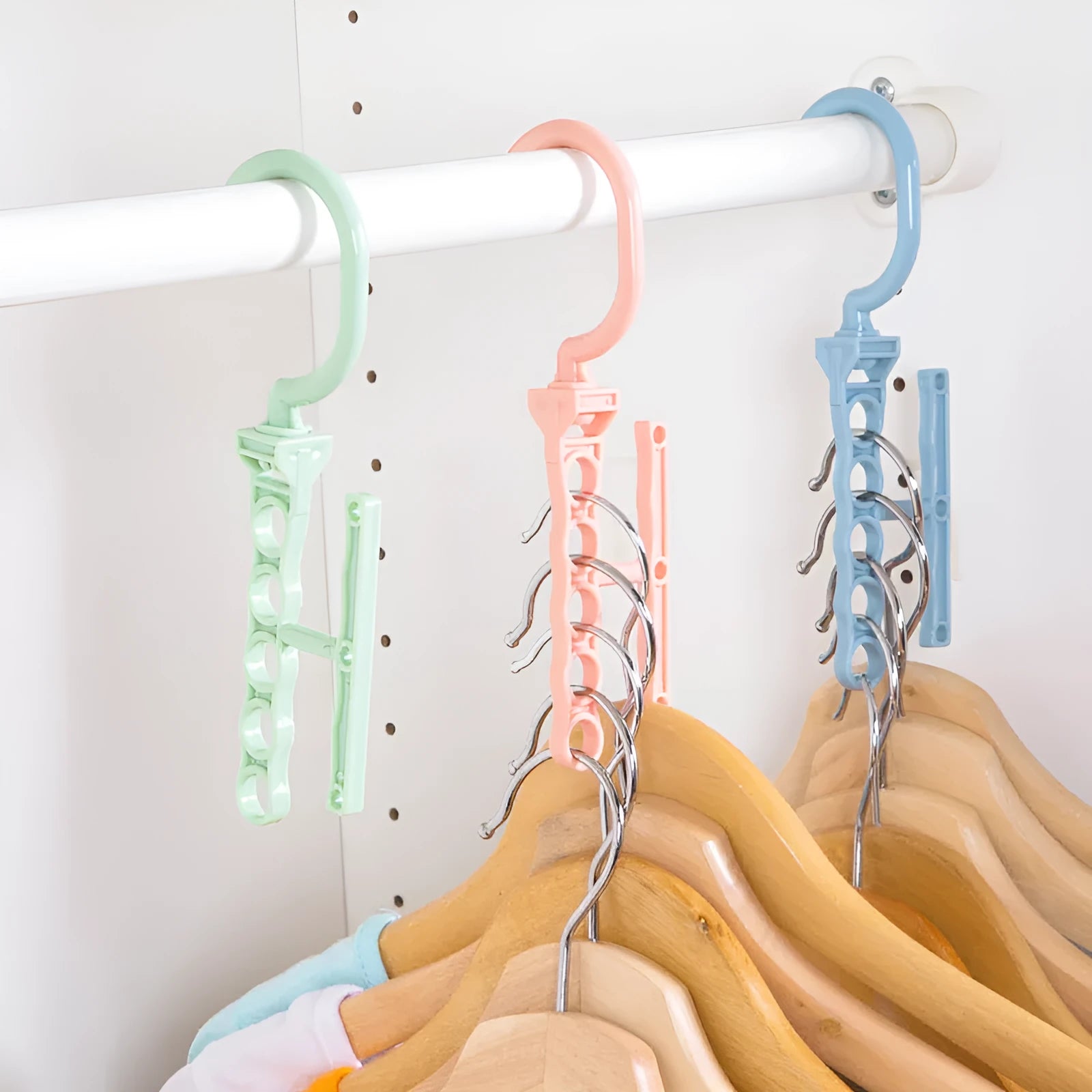 Blue revolving wardrobe hanger with five branches and a handle for multiple garment organisation.