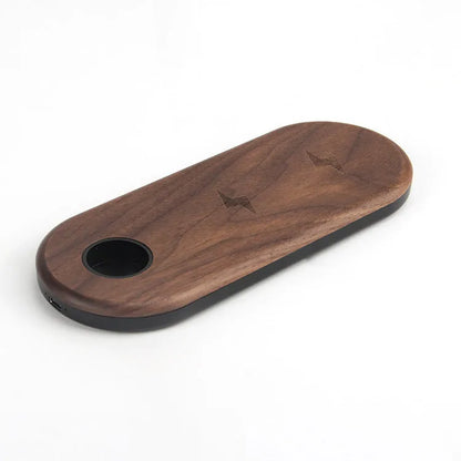 Ultra-thin bamboo and wood wireless charging stand for smartphones on a desk.