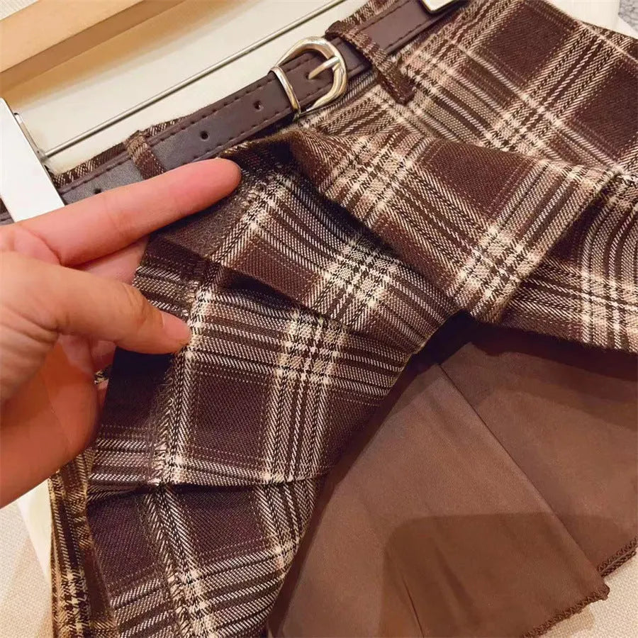 Girls' plaid pleated A-line skirt in cotton blend fabric, shown on a hanger.
