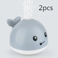 Grey or white electric whale bath toy spraying water with LED lights on a base.