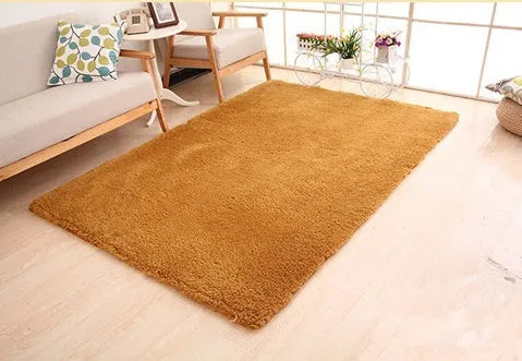 Solid colour plush rectangle area rug with soft texture on a wooden floor.