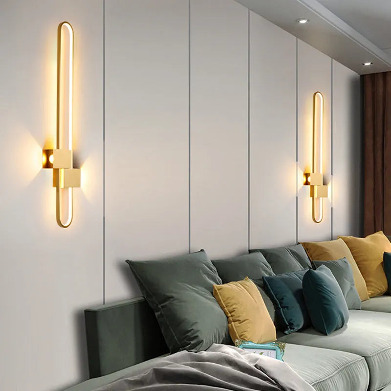 Modern round wall lamp with black iron shade and warm LED light, mounted on a grey wall.