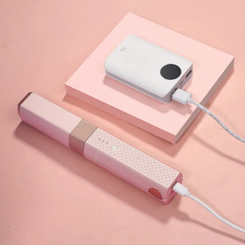 Pink and green cordless mini USB hair straightener and curler with ceramic plates.