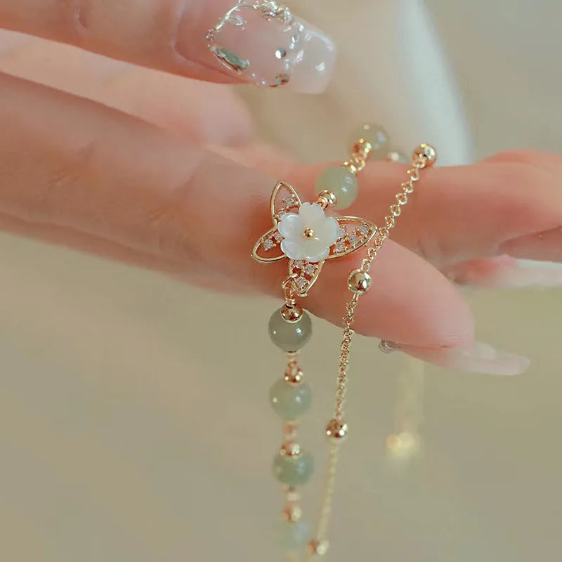 Butterfly bracelet for women crafted from copper with electroplated yellow gold finish, featuring intricate Hetian jade bell design and geometric shapes, a detailed fashion accessory suitable for daily wear and special occasions