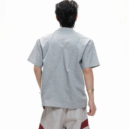 Men's loose fit black cotton T-shirt with textured pleats and asymmetric stitching detail.