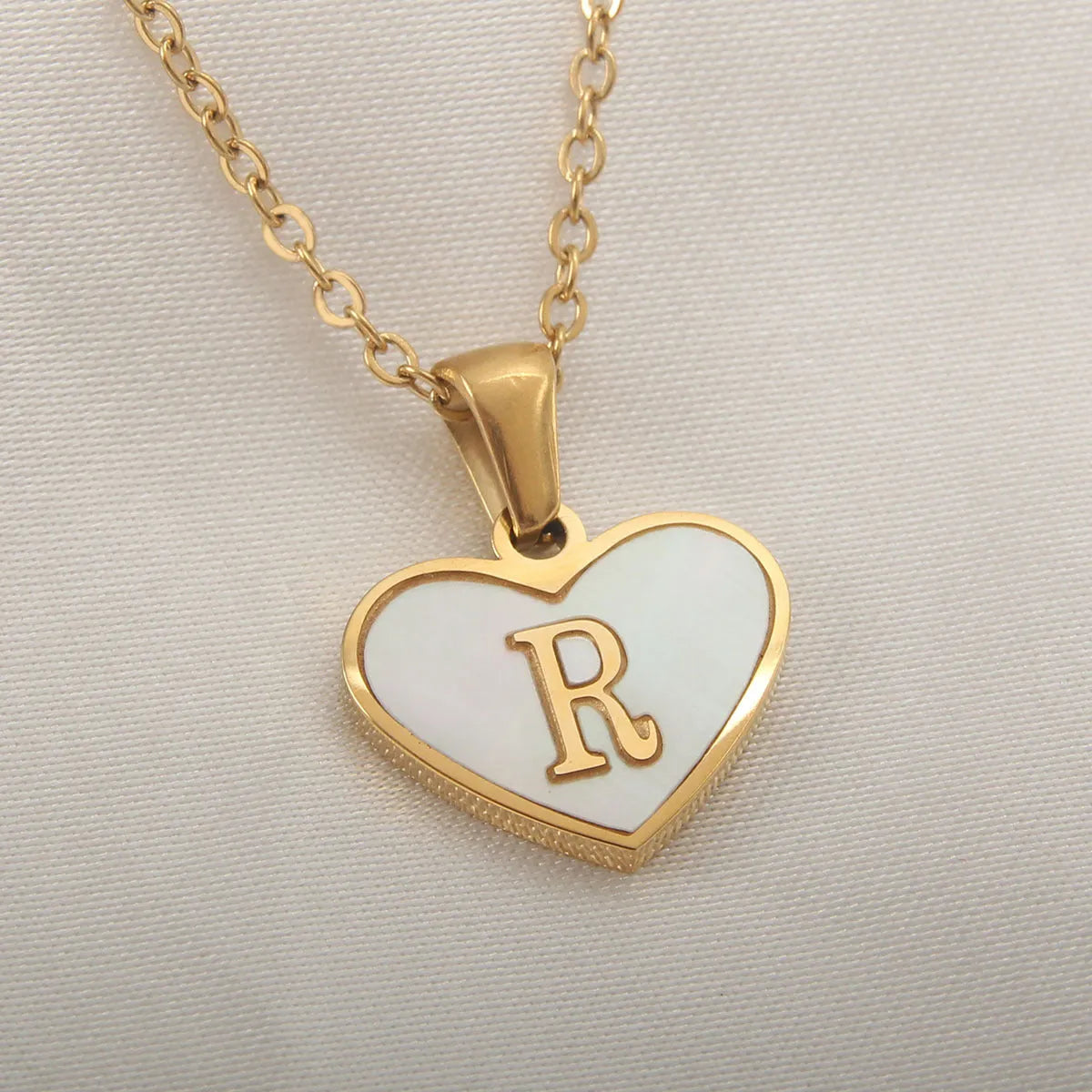 Gold-plated heart necklace with white shell pendant showing letter personalisation option