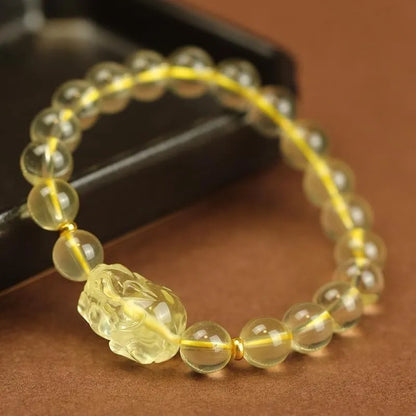 Yellow artificial crystal Pi Xiu charm on a leather bracelet, shown with different bead size options.