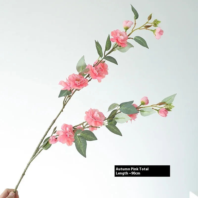 Artificial silk camellia flower in a vase, colours include white, pink, rose pink, and orange coffee.