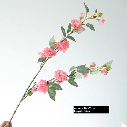 Artificial silk camellia flower in a vase, colours include white, pink, rose pink, and orange coffee.