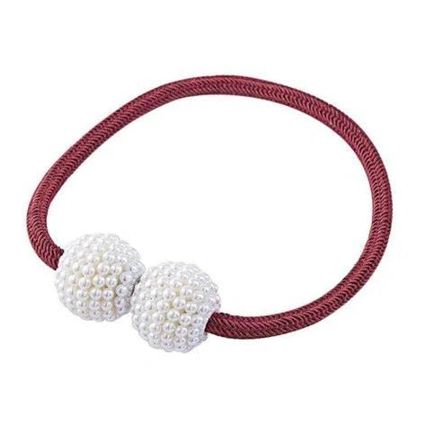 Magnetic curtain tiebacks with white pearl beads and fabric loops holding gathered curtain