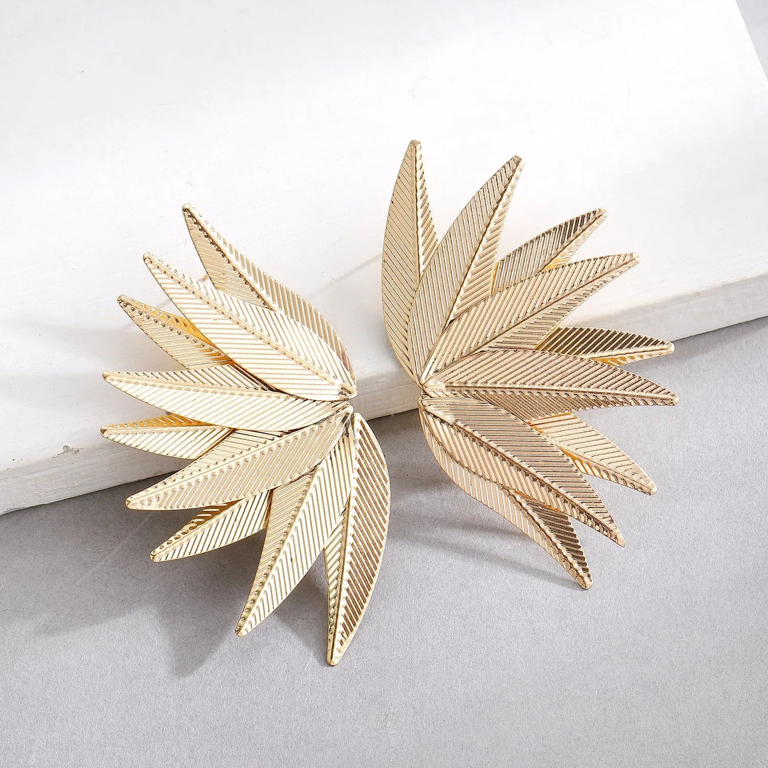 Gold and white alloy leaf-shaped patch earrings with botanical design