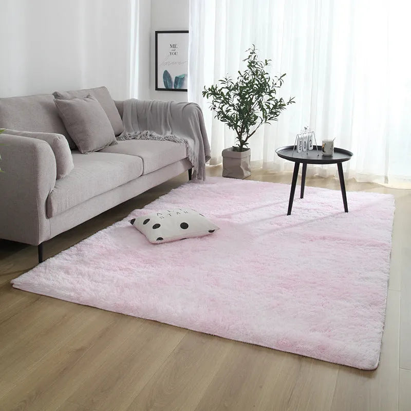 Soft fluffy plain rectangle carpet with anti-slip dots on backing, shown in a light grey colour on a wooden floor.