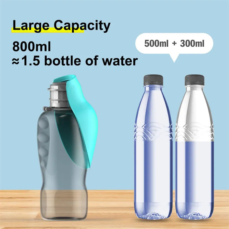 Blue grey portable dog water bottle with fold-out drinking bowl, shown with a wrist strap.