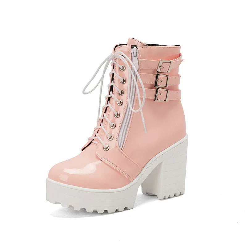 Women's black chunky heel ankle boots with round toe and front lace-up on a wooden floor.