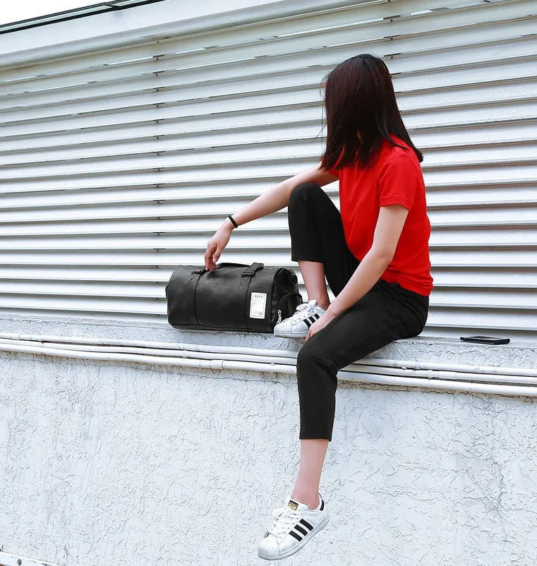 Black waterproof sports bag with separate shoe compartments on the sides, shown with adjustable diagonal strap.