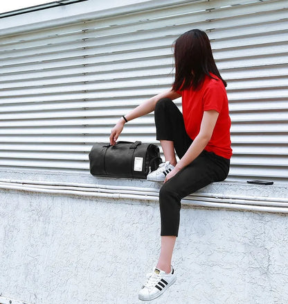 Black waterproof sports bag with separate shoe compartments on the sides, shown with adjustable diagonal strap.