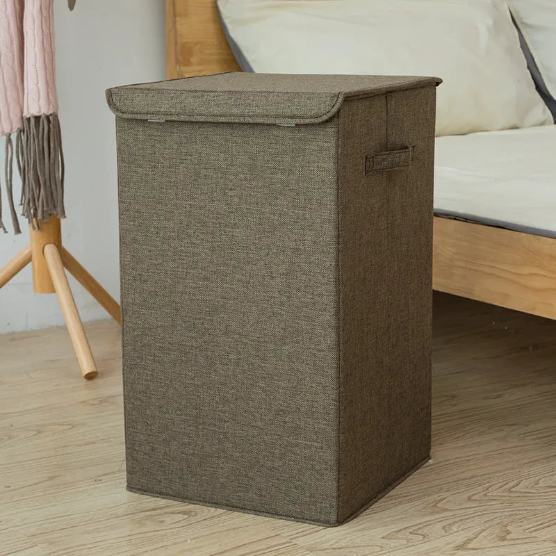 Foldable cube-shaped laundry basket in cotton linen fabric, shown in brown colour.