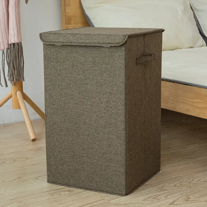Foldable cube-shaped laundry basket in cotton linen fabric, shown in brown colour.