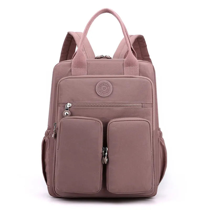 Women's waterproof nylon travel backpack in grey, showing front external pocket and organisational interior.