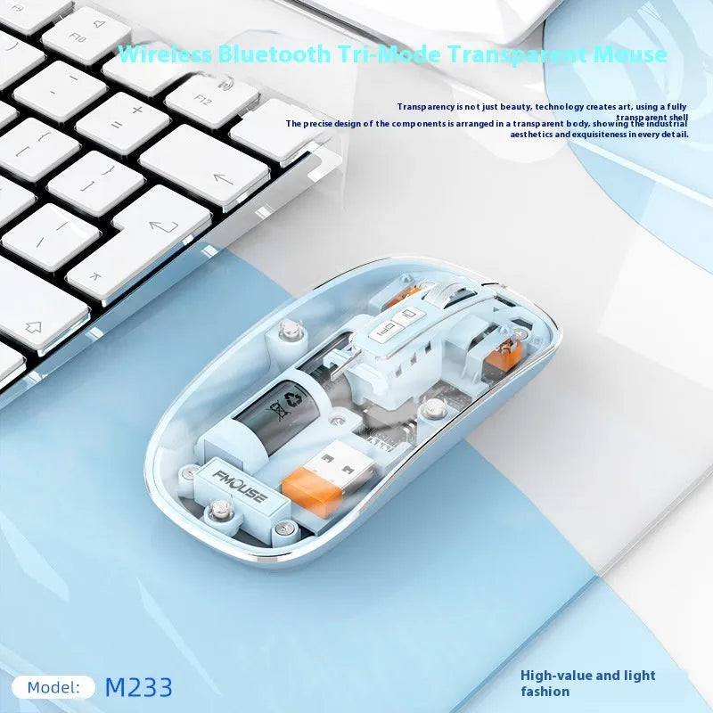 Transparent wireless computer mouse in blue on a desk next to a laptop