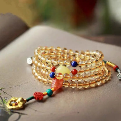 Yellow natural Brazilian citrine bracelet with 1mm beads on a gold-tone filament string.