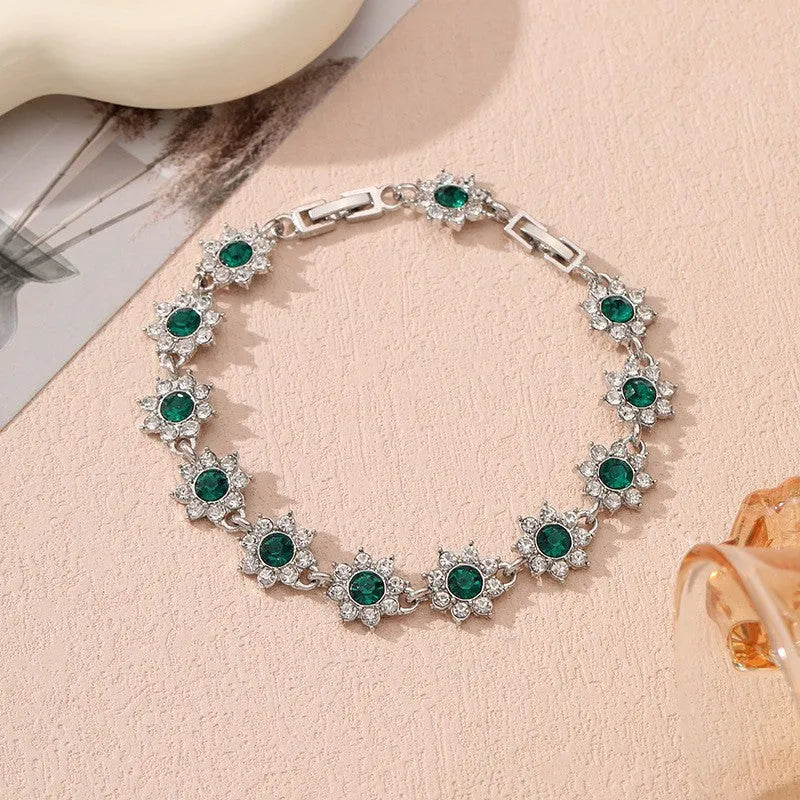 Gold and silver electroplated bracelets with flower charms set with coloured gemstones.