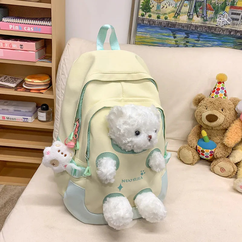 Macaron colour nylon school backpack with curved straps, shown in yellow pink, with a pendant attached.