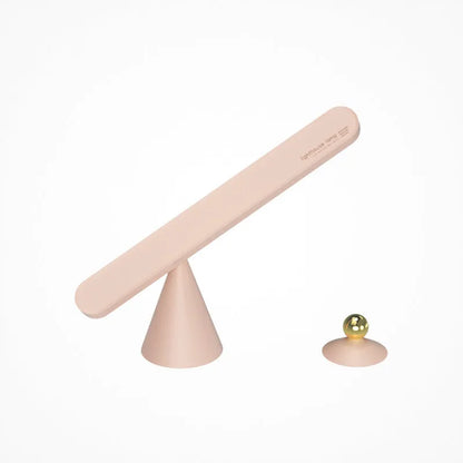 White geometric desk lamp with magnetic base and touch control on a wooden table.