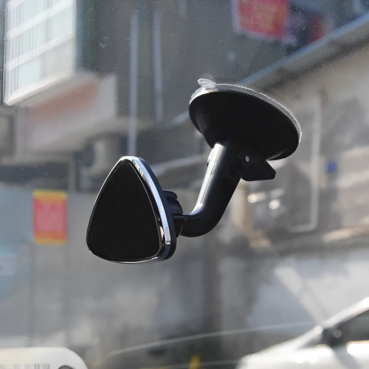 Black magnetic car phone holder with rotating head shown mounted on dashboard