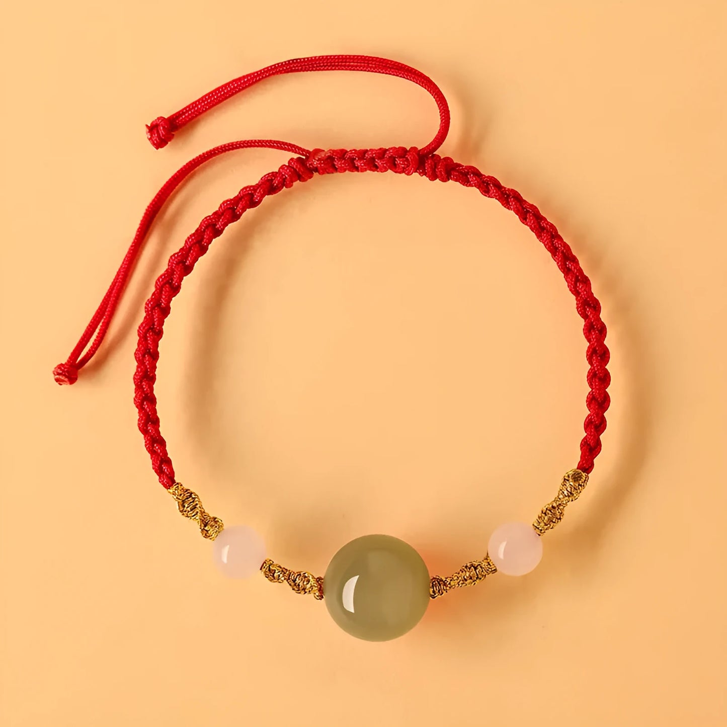 Hand-woven red rope bracelet with Hetian jade lucky beads on a wrist.