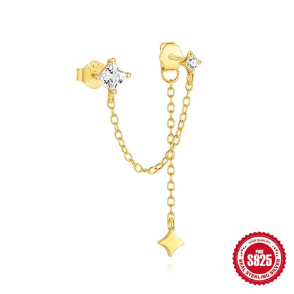 Close-up of a sterling silver double piercing chain stud earring with inlaid zircon stone in a golden colour.
