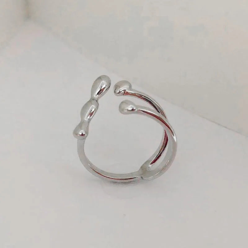 A minimalist brass ring with a small spherical detail on a plain band, shown in gold tone.