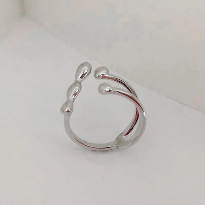 Gold adjustable open ring with spherical details on a woman's hand, showing the 1cm gap.