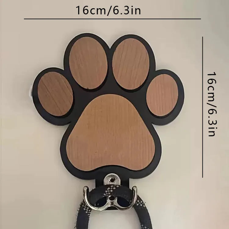 Black wooden wall hook shaped like a paw print foot on a white wall