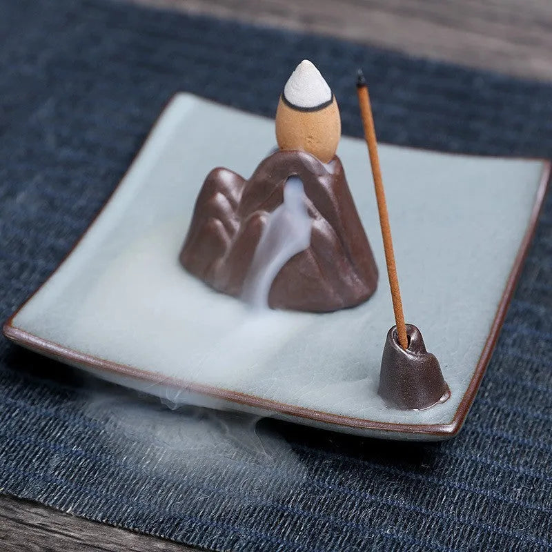 Square ceramic incense burner with reverse flow design showing smoke cascading down sides, Ge kiln crackle glaze patterns visible