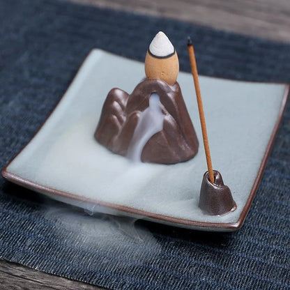 Square ceramic incense burner with reverse flow design showing smoke cascading down sides, Ge kiln crackle glaze patterns visible