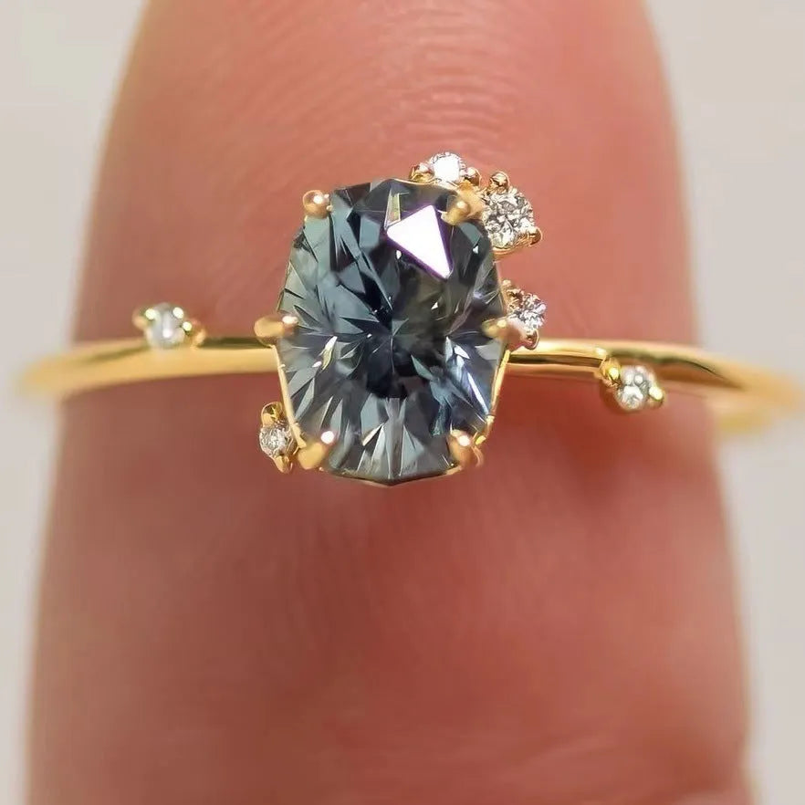 Gold-plated floral women's ring with a green zircon stone centrepiece on a model's hand.