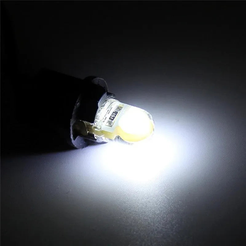 Pack of ten T10 wedge base LED car bulbs with COB chips in various colours on a white background