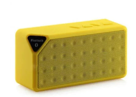 Cannon X3 small cube-shaped wireless Bluetooth speaker in multiple colours on a table.