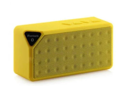 Cannon X3 small cube-shaped wireless Bluetooth speaker in multiple colours on a table.