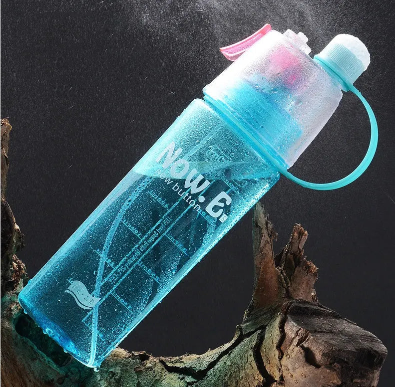 Green mist spray sports water bottle with handle, scale, and press-top lid on a gym bench.