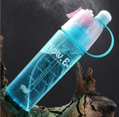 Green mist spray sports water bottle with handle, scale, and press-top lid on a gym bench.