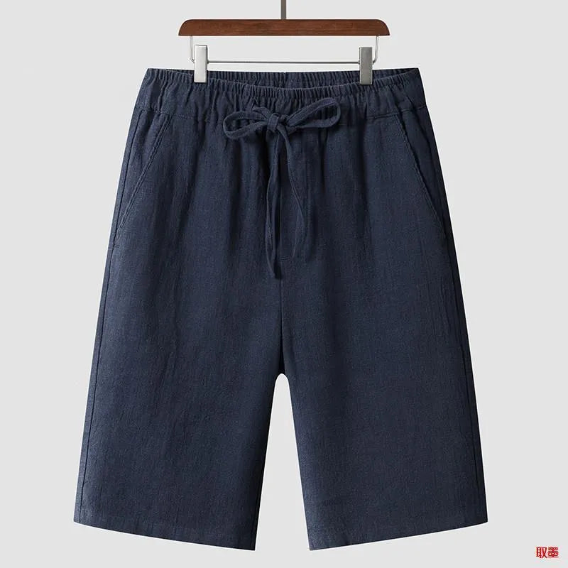 Men's beige linen casual shorts with a loose fit and elastic waistband on a neutral background.
