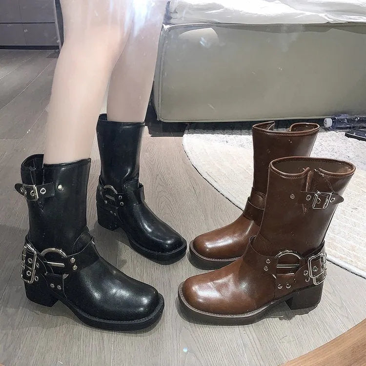 Women's black platform ankle boots with a silver buckle on the shaft, shown in a middle-calf length style.