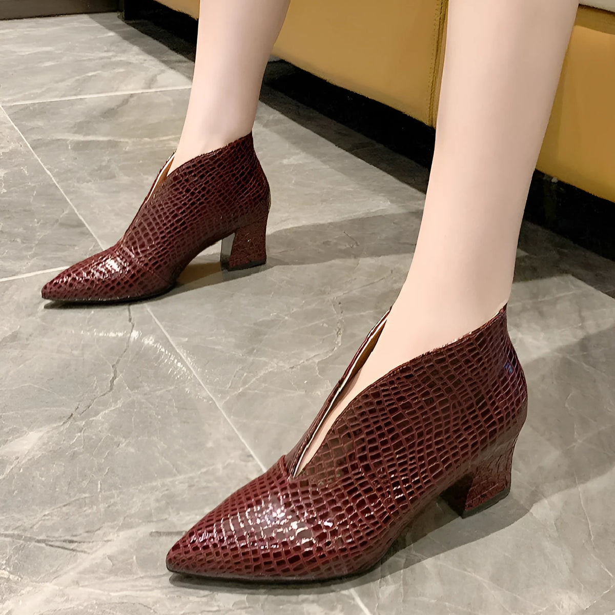 Women's black V cut Martin boots with a pointed embossed toe and a chunky heel.
