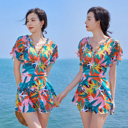 Women's colourful printed one-piece swimsuit on a mannequin, showing full coverage design.