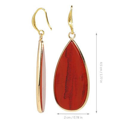 Handmade vintage long water drop earrings with tigereye stone and sterling silver hooks on a textured background.